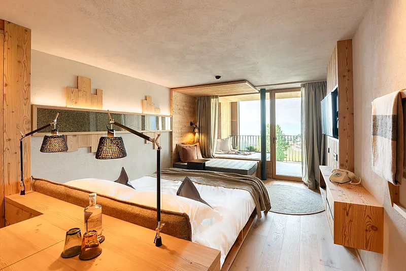 Die Zimmereinrichtung ist in Naturholz gehalten. Vor dem Zimmer erstreckt sich ein eigener Balkon