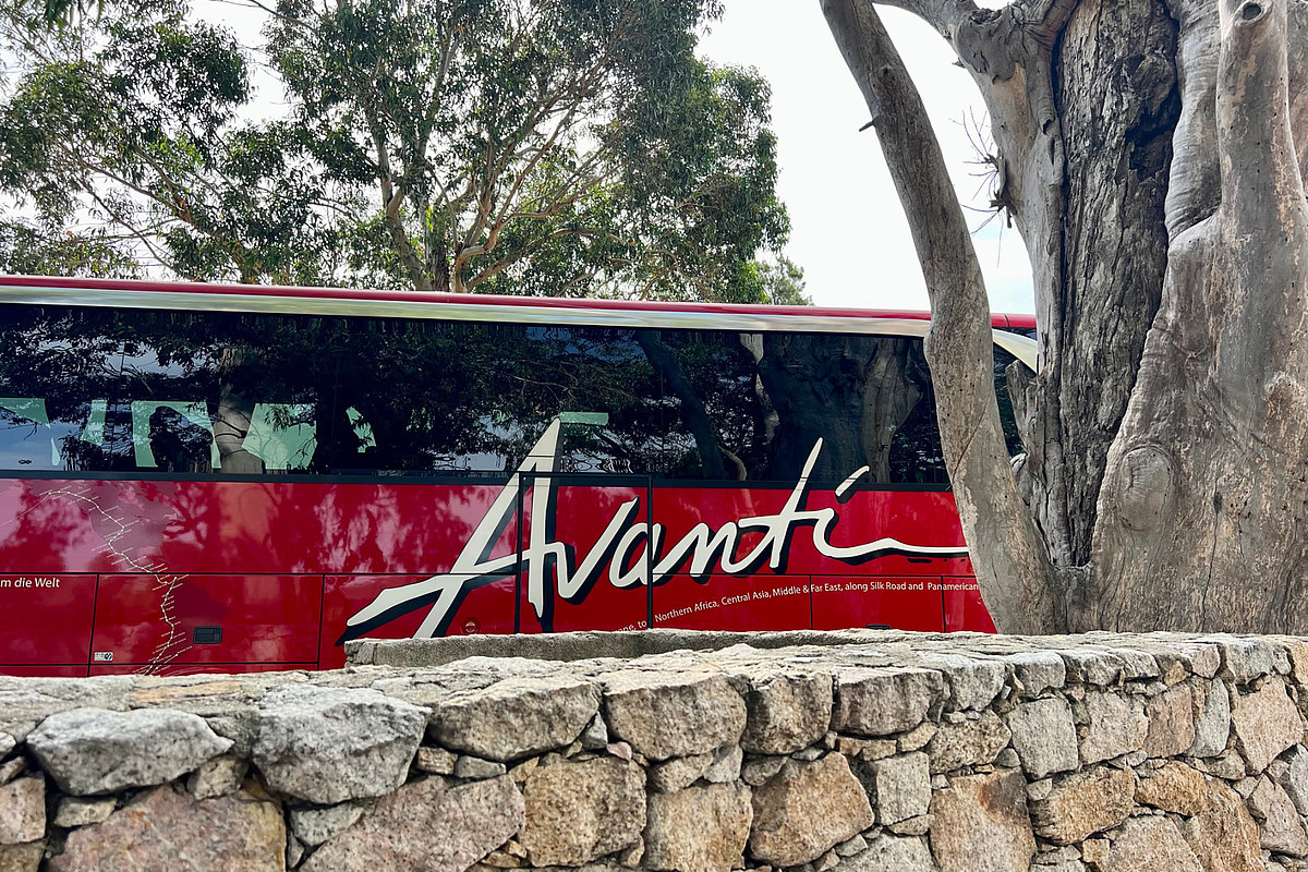 Roter Bus hinter einer Steinmauer