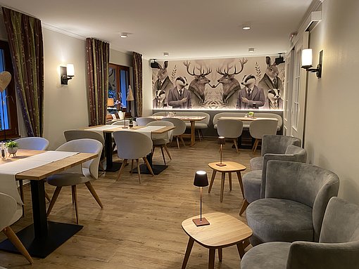 Blick in einen Bar- und Restaurantbereich mit Tischen und Stühlen