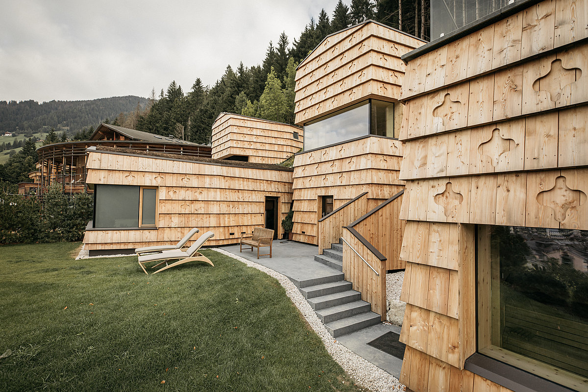 Gebäudefassade aus Holz mit Wald im Hintergrund