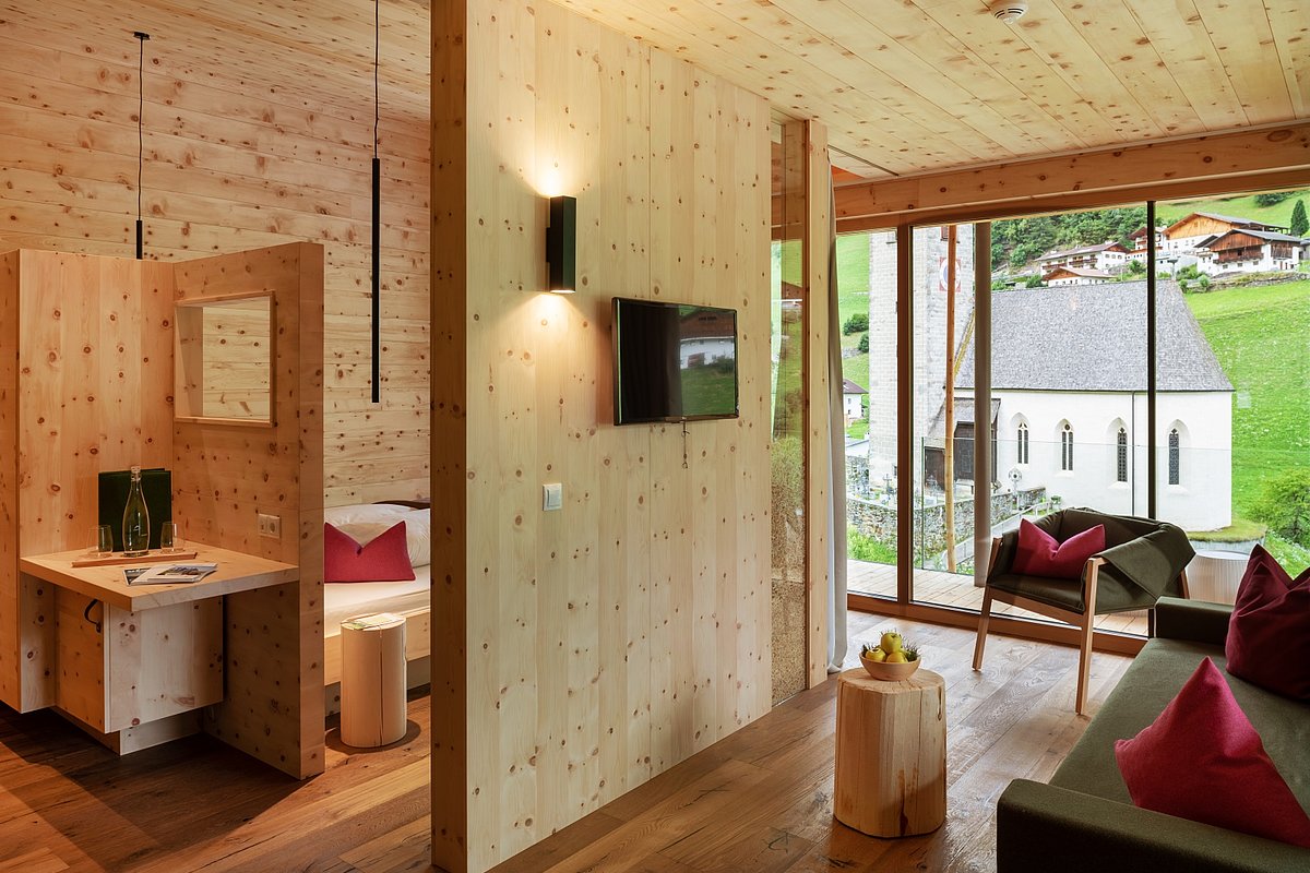 Ein Hotelzimmer mit viel Holz und großem Fenster