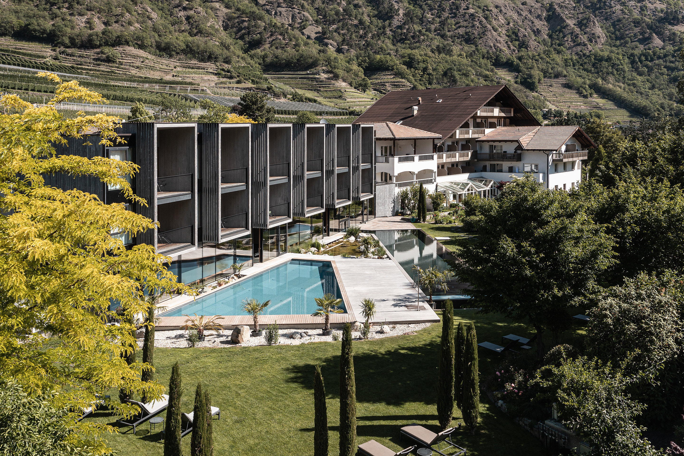 Außenansicht eines Hotels mit Gartenanlage und Pool