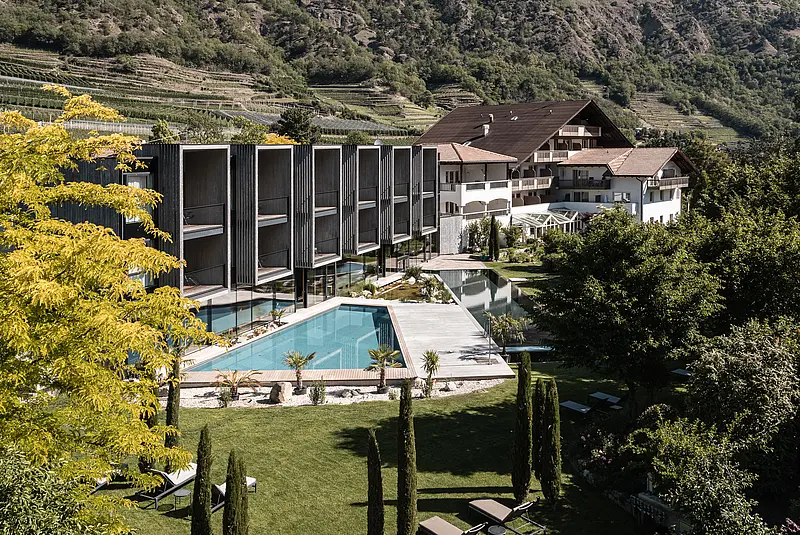 Außenansicht eines Hotels mit Gartenanlage und Pool