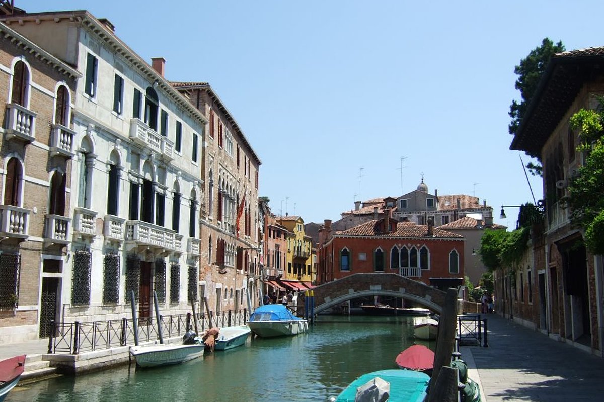 Eine breite Gasse in Venedig mit einer Brücke, die über den Kanal verläuft