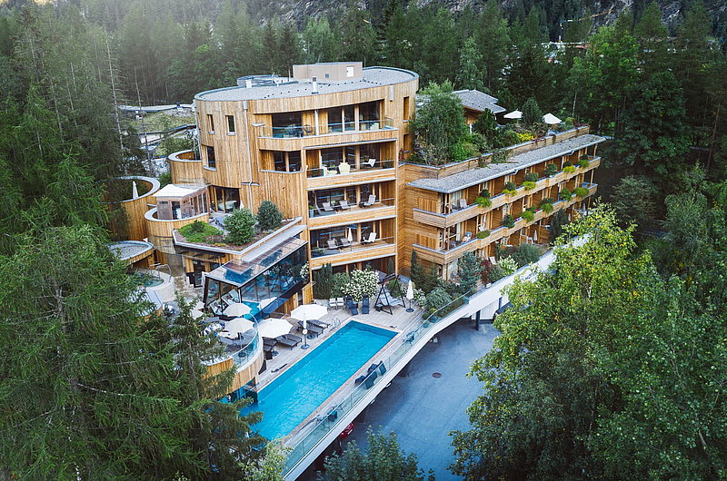 Gesamtansicht eines Hotels aus Holz mit Pool