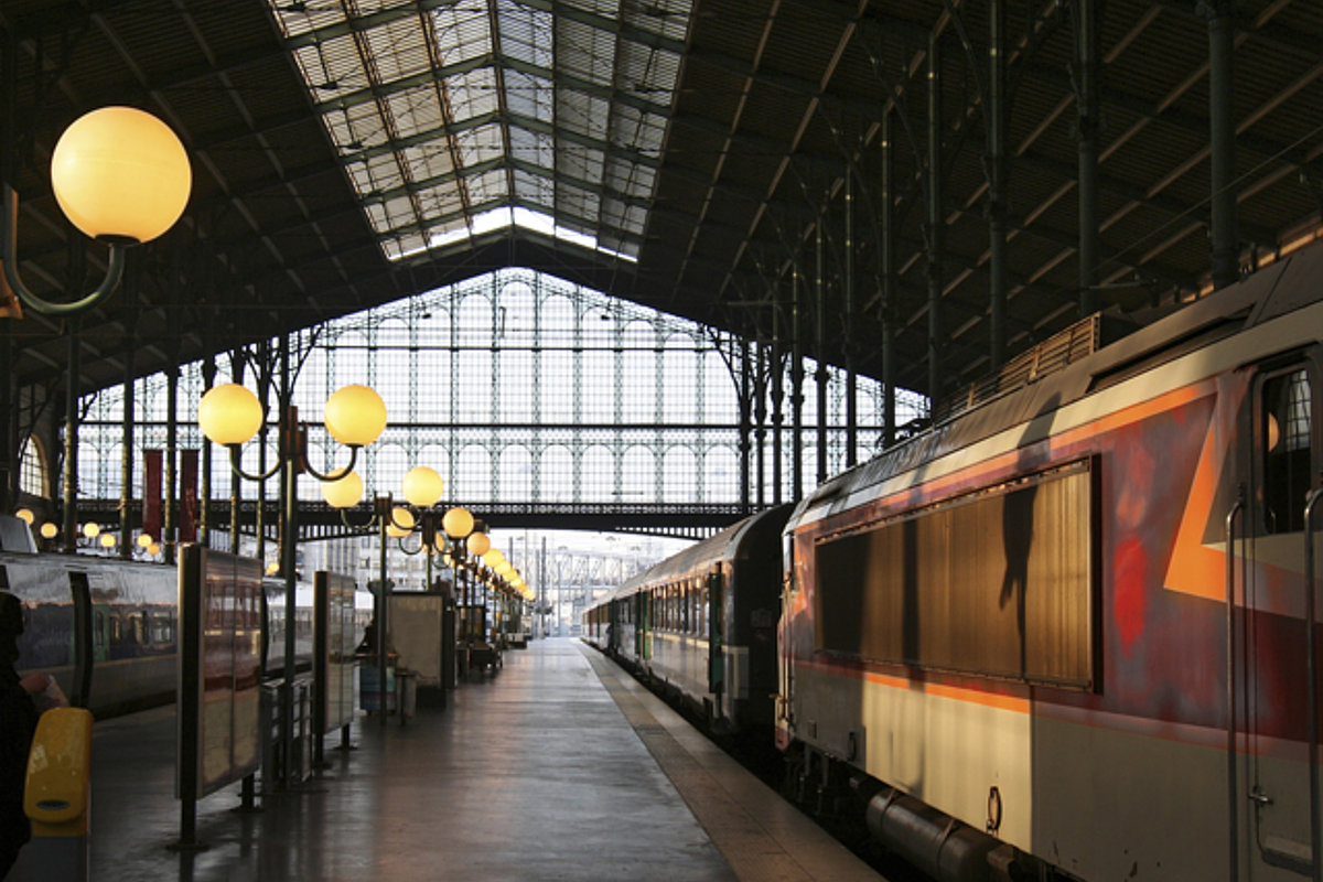 Bahnhofshalle mit Bahnsteig und Personenzug