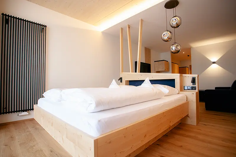 Blick in ein geräumiges modernes Hoteldoppelzimmer mit Holzfußboden