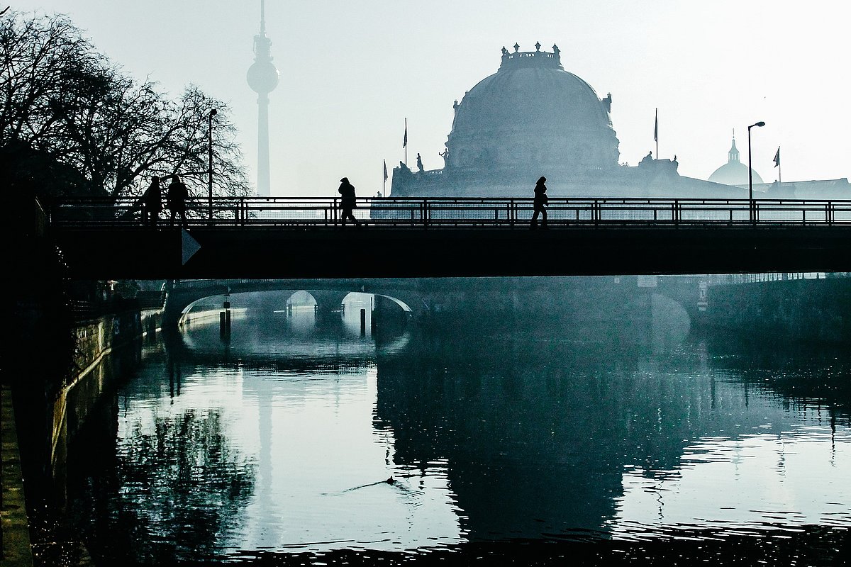 Blick auf eine Berliner Brücke im Morgennebel mit der Stadt im Hintergrund