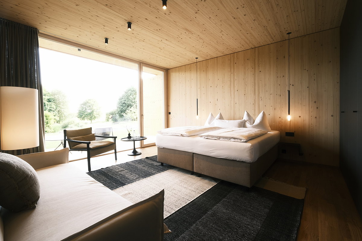 Modernes Hotelzimmer mit viel Holz und Doppelbett
