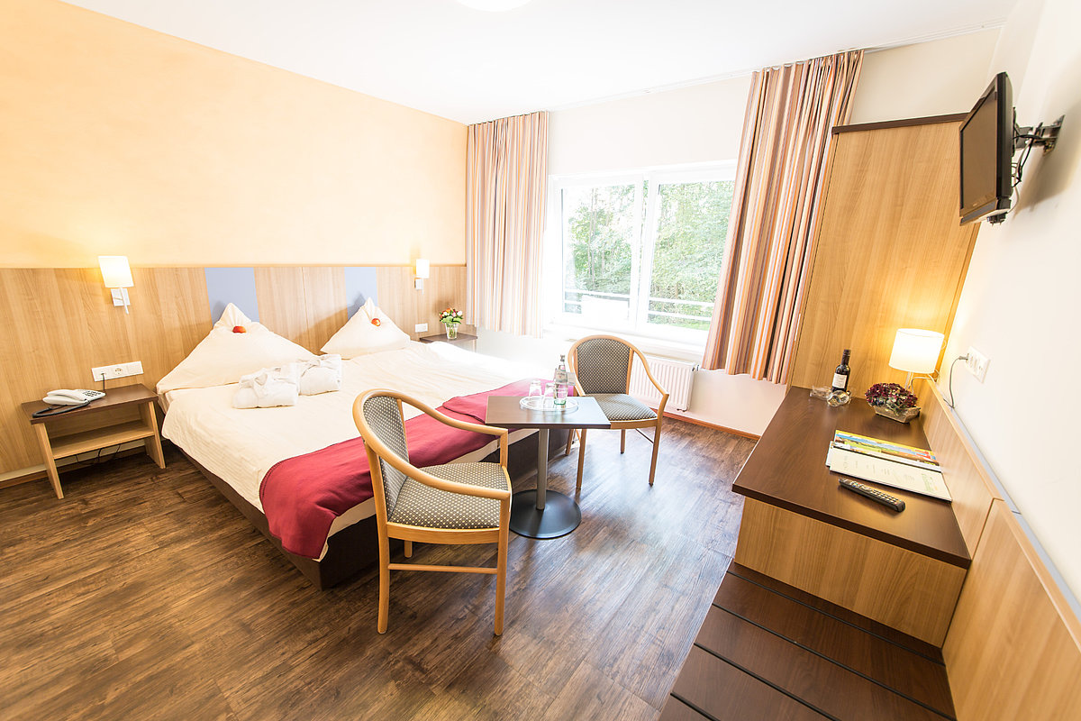 Ein Hotelzimmer mit viel Holz und Doppelbett