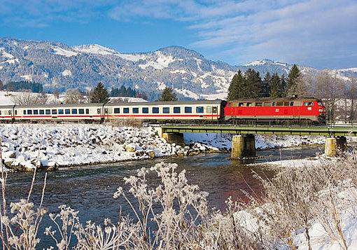 Ein Zug fährt über eine Brücke im Winter
