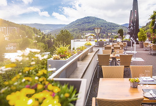 Restaurant-Terrasse mit Tischen und Stühlen zu Panoramabergblick