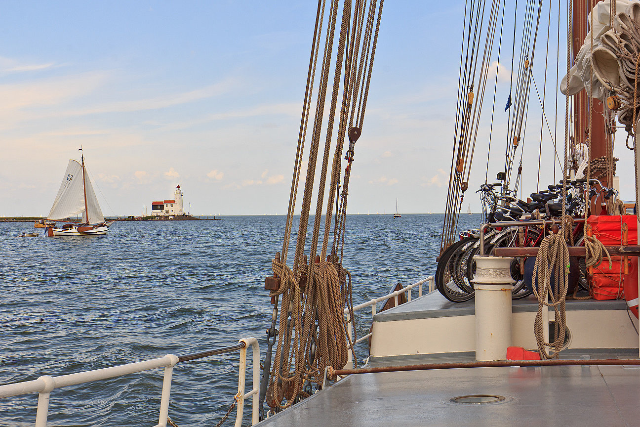 Auf dem Segelschiff, mehrere Fahrräder, Leuchtturm im Hintergrund, weiteres Segelboot