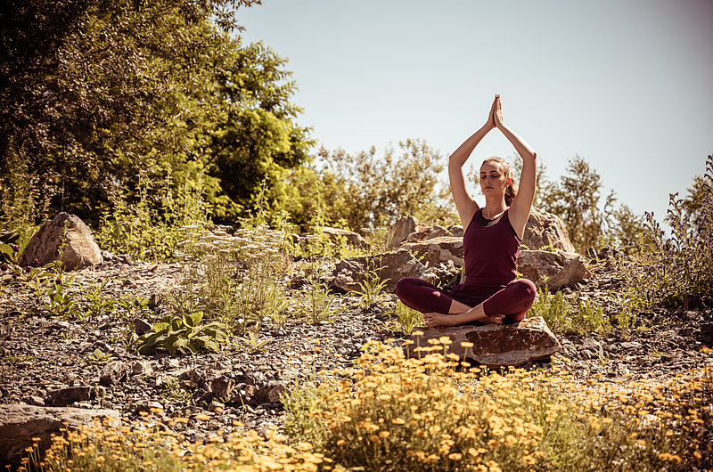 Eine Frau macht Yoga in einem Garten