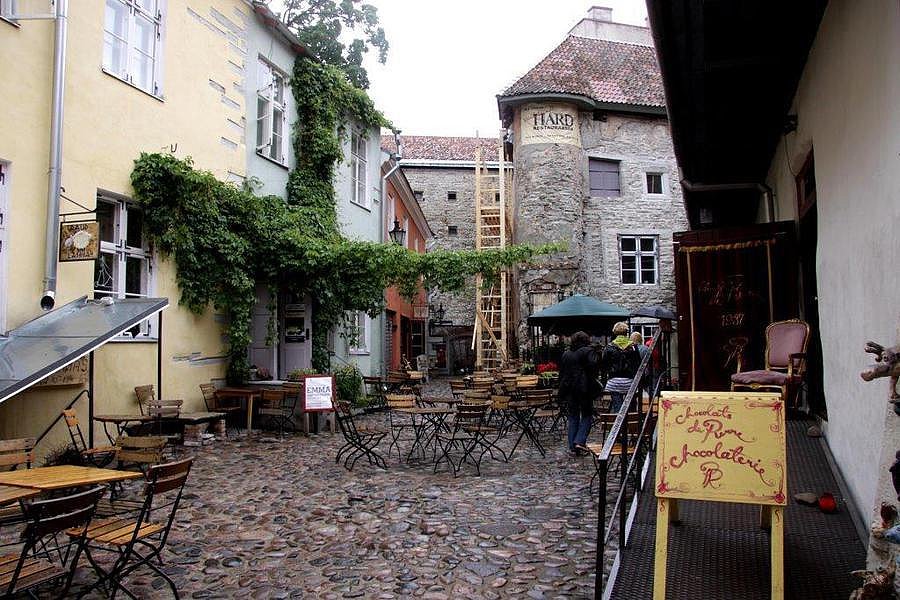 Tische und Stühle eines Cafés in der steingepflasterten Altstadt